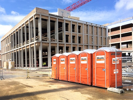 Five portable toilets at a construction site